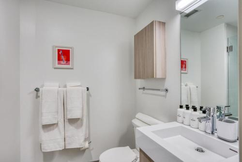 uma casa de banho branca com um lavatório e um WC em Kendall Square 2br w gym near shops dining BOS-974 em Cambridge