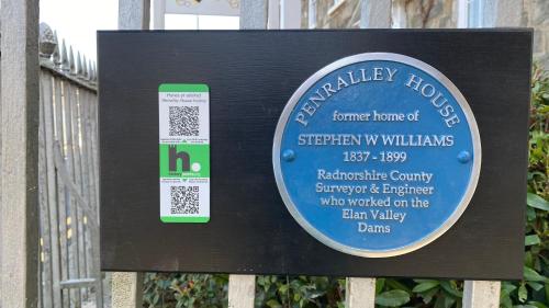 a sign on a fence with a sign for a house at Penralley House B&B in Rhayader