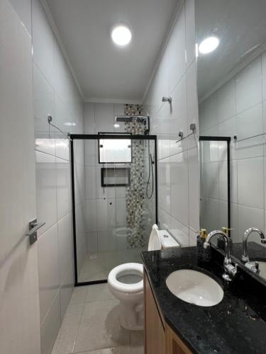 a bathroom with a shower and a toilet and a sink at Casa de Campo Terra Preta in Mairiporã