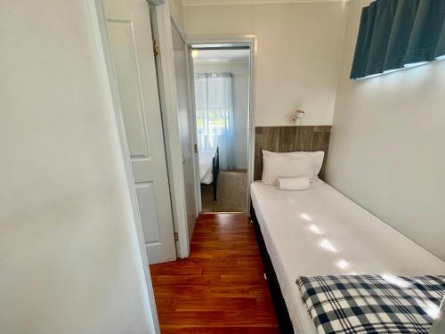 a small room with a bed and a hallway at Young Caravan and Tourist Park in Young