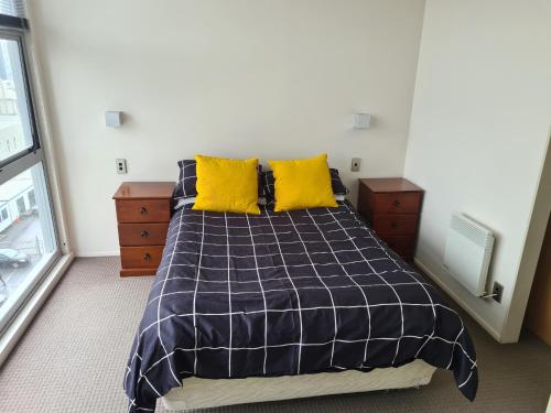 um quarto com uma cama com almofadas amarelas em Boutique Hotel Complex Apartment with Hot Tub, Pool & Gym em Wellington