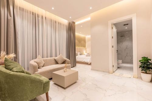 Amber Hospitality - Al Qairawan في الرياض: غرفة معيشة مع أريكة وسرير