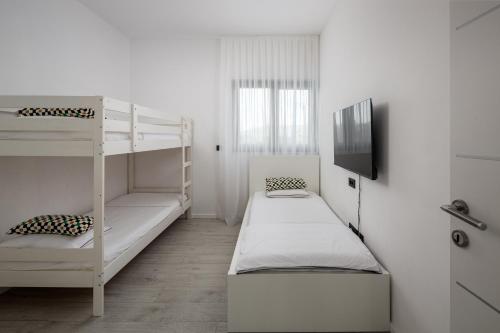 a room with two bunk beds and a flat screen tv at Villa A in Bilice