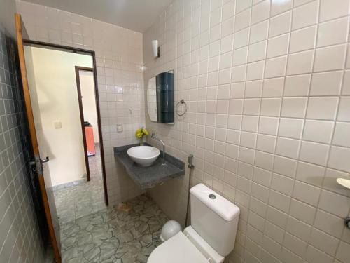 La salle de bains est pourvue de toilettes, d'un lavabo et d'un miroir. dans l'établissement Casa de Praia beira-mar, à Lucena