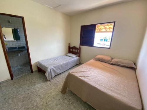- une chambre avec 2 lits et une fenêtre dans l'établissement Casa de Praia beira-mar, à Lucena
