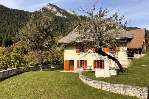 een stenen huis met een stenen muur eromheen bij Le Nid de Pajonnière en chartreuse in Saint-Pierre-de-Chartreuse