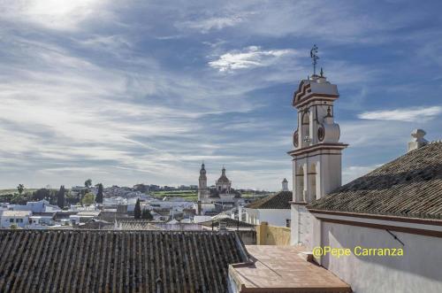 a view of a city with a clock tower at Santa Angela de la Cruz in Peñaflor