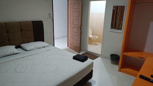 a bedroom with a bed and a bathroom with a toilet at IHomestay Pekanbaru in Pekanbaru