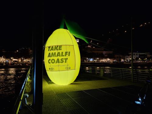 a large yellow sign on a dock at night at TakeAmalfiCoast Patchwork Rural House in Minori
