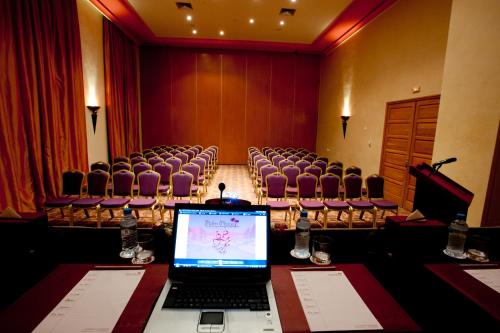 a laptop computer on a table in a room with chairs at Palm Plaza Marrakech in Marrakech