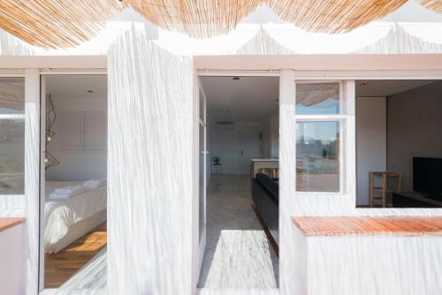 een kamer met witte muren en een slaapkamer met een bed bij Apartamento Corall in Blanes