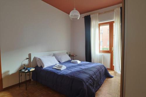 a bedroom with a blue bed and a window at Delightful shanti home in Milan