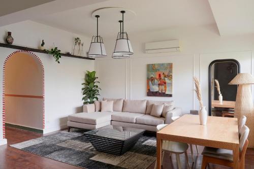 uma sala de estar com um sofá e uma mesa em Designer Baron Palace 4BR Garden Duplex no Cairo