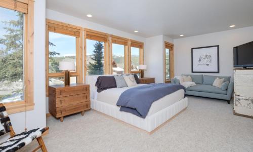 a bedroom with a bed and a couch and windows at Black Eagle 12 in Big Sky