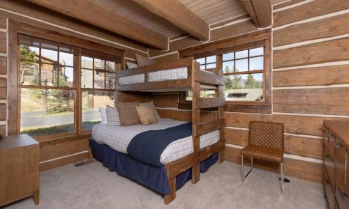 um quarto com um beliche num chalé de madeira em Powder Ridge Cabin Oglala 2B em Big Sky