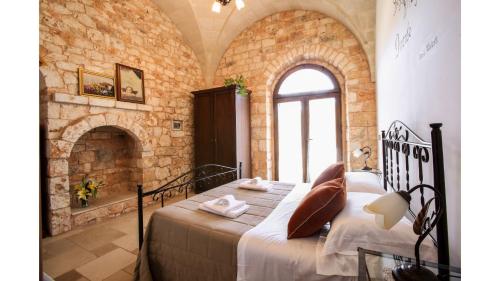 ein Schlafzimmer mit einem Bett in einer Steinmauer in der Unterkunft trullo degli ulivi con piscina e vasca per bambini in San Michele Salentino