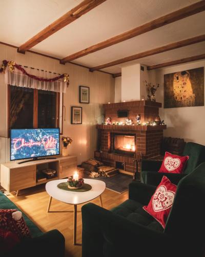 a living room with a fireplace and a television at Jarzębinowa - Dom do wynajęcia na Podlasiu in Łuka