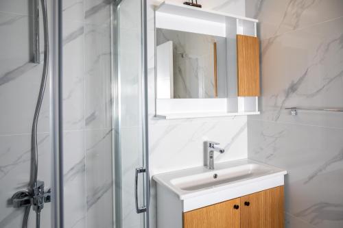 a bathroom with a sink and a shower at Caesar Blue Seaside Luxury Apartments in Kalecik