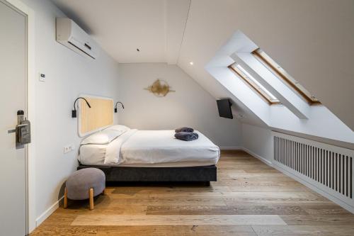 a bedroom with a bed in a attic with skylights at ESE HOTEL in Birštonas