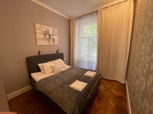 a bedroom with a bed with two towels on it at Holec Apartments in Prague