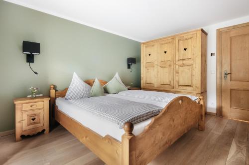Schlafzimmer mit einem Holzbett und einem Holzschrank in der Unterkunft Die Suttenhütte in Rottach-Egern