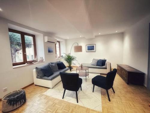 sala de estar con 2 sofás, mesa y sillas en Chambre Rose des Vents en Eguisheim