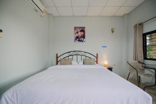 a bedroom with a large white bed in a room at ไร่นภาดลรีสอร์ท in Mae Suai