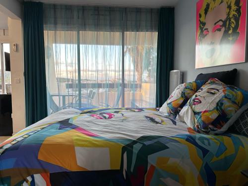 - un lit coloré dans une chambre avec fenêtre dans l'établissement Village naturiste - Port-Nature 7 - Le Maryline - 3ème étage - vue Port, au Cap d'Agde