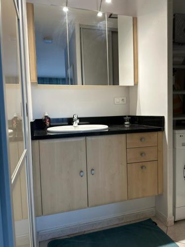 une salle de bain avec un lavabo et un miroir dans l'établissement Village naturiste - Port-Nature 7 - Le Maryline - 3ème étage - vue Port, au Cap d'Agde