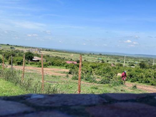 a person walking in a field behind a fence at Luluka Guest House in Sekenani