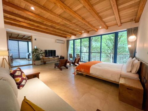 a bedroom with a large bed and a living room at 慎重開華莊園民宿 in Puli