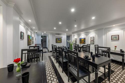 a dining room with black tables and chairs at Paddy Hotel in Ha Long