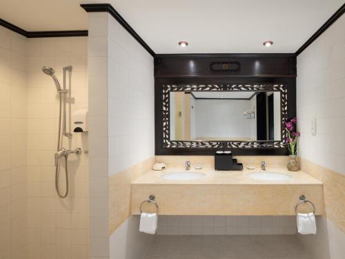 a bathroom with two sinks and a mirror at Nirwana Resort Hotel in Lagoi