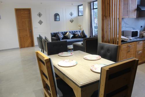 a dining room with a table and chairs and a couch at Kasauli Hill Crest Luxury 2BHK Apartment in Kasauli