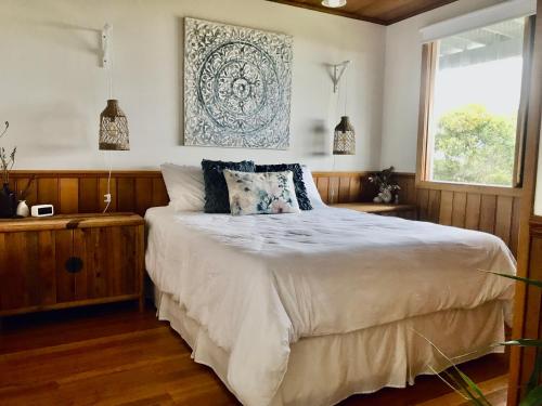 ein Schlafzimmer mit einem großen Bett und einem Fenster in der Unterkunft Sandy Toes in Greens Beach