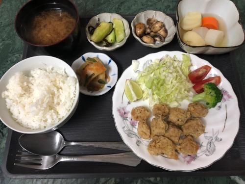 - un plateau avec une assiette de nourriture à base de riz et de légumes dans l'établissement Momotaro House, à Bodh Gaya