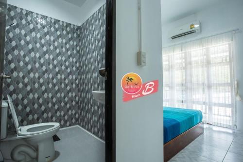 a bathroom with a toilet and a bed in a room at Tamtawan Guesthouse - ตามตะวันเกสเฮ้าส์ in Ko Lipe