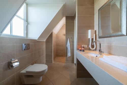 uma casa de banho com um lavatório e um WC em Villa Oranjezon by Droomvilla em Colijnsplaat
