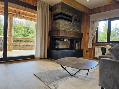 a living room with a table and a fireplace at Domek LUNA in Olchowiec