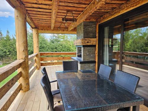a patio with a table and chairs on a deck at Domek LUNA in Olchowiec