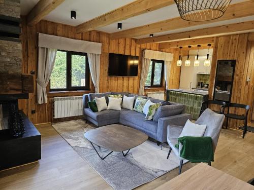 a living room with a couch and a table at Domek LUNA in Olchowiec