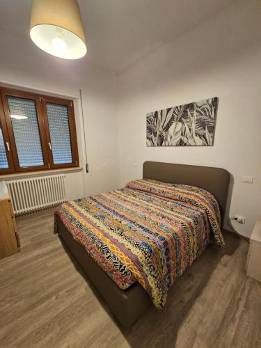 ein Schlafzimmer mit einem Bett mit einer bunten Decke darauf in der Unterkunft APPARTAMENTO IL VELINO in Rocca di Mezzo