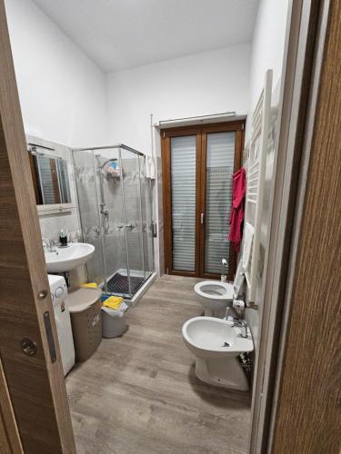 ein Badezimmer mit 2 Waschbecken, einer Dusche und 2 WCs in der Unterkunft APPARTAMENTO IL VELINO in Rocca di Mezzo