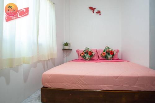 a bedroom with a pink bed with pink sheets and a window at Tamtawan Guesthouse Lipe - ตามตะวันเกสเฮ้าส์ หลีเป๊ะ in Ko Lipe