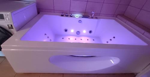 e bagno con vasca bianca e piastrelle viola. di MY apartement, 3 tuba, privaatne sissekäik a Tartu