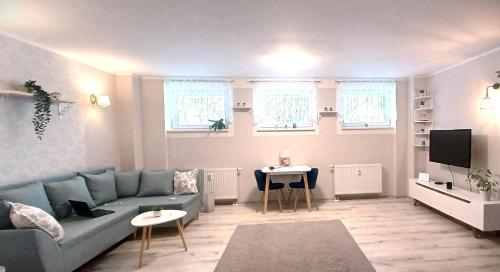 un soggiorno con divano blu e tavolo di MY apartement, 3 tuba, privaatne sissekäik a Tartu