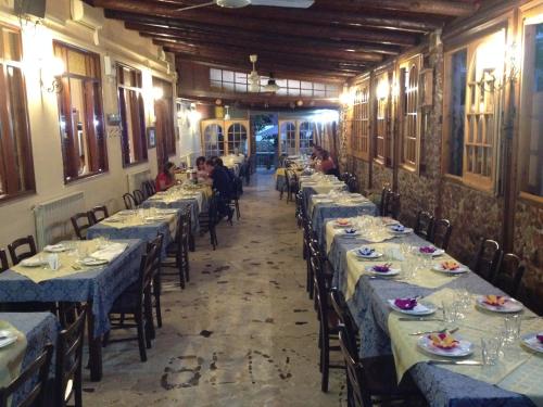 una fila di tavoli in un ristorante con persone sedute al loro posto di Hotel Il Pirata a Cinisi