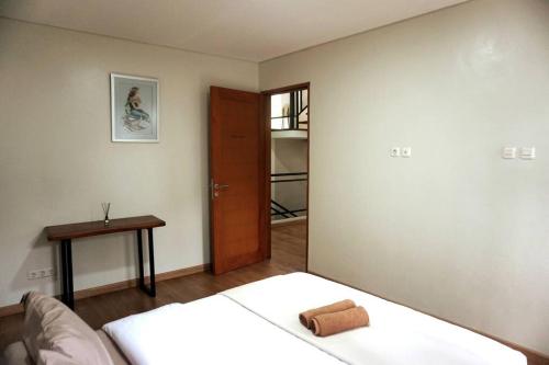 een slaapkamer met een bed, een tafel en een deur bij One O Two Villa in Bandung