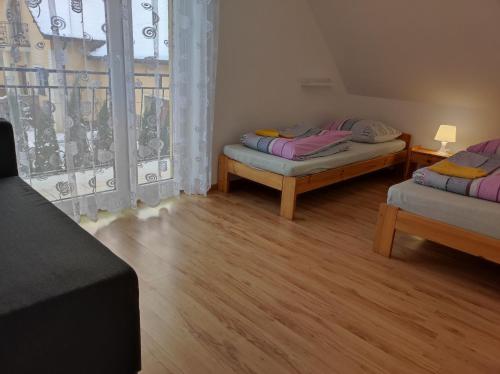 a room with two beds and a window at Górski Kryształ in Stronie Śląskie