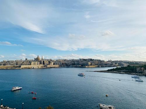 Blick auf einen Fluss mit Booten in einer Stadt in der Unterkunft Sliema Seaview & seafront- APT 9, 49 Tigne Point Mansions in Sliema